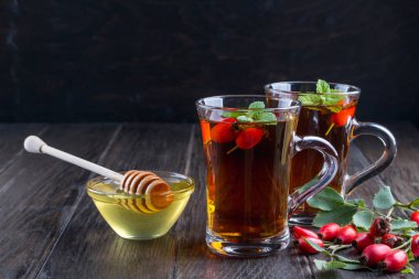 Sağlıklı sonbahar çay şube meyveleri koyu arka plan üzerinde ile köpek Güllü.