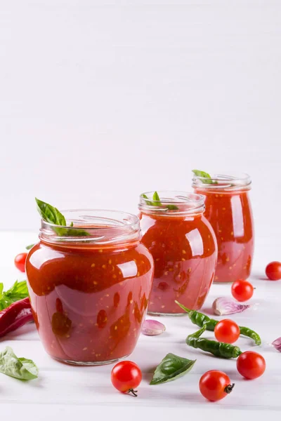 Salsa picante de tomate dulce con ajo, pimienta y hierbas en frascos de vidrio . — Foto de Stock