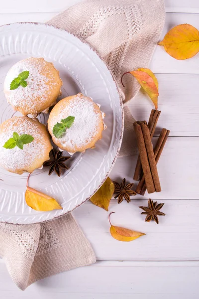 Cupcakes caseiros com açúcar em pó com paus de canela, estrelas de anis e folhas de outono — Fotografia de Stock