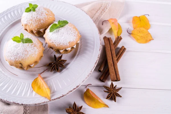 Cupcakes caseiros com açúcar em pó com paus de canela, estrelas de anis e folhas de outono — Fotografia de Stock