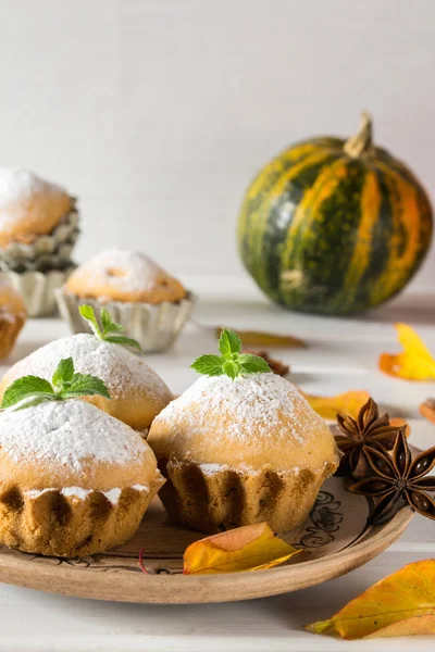Outono ainda vida. Cupcakes caseiros com açúcar em pó com paus de canela, estrelas de anis e folhas de outono — Fotografia de Stock