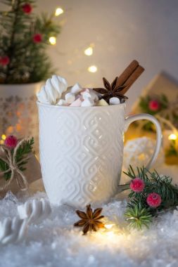 Beyaz fincan sıcak baharatlı Noel içecek ve yılbaşı süsleri.