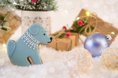 Bir köpek şeklinde kurabiyeler. Yeni yıl parlak dekorasyon ve armağan üstünde açık renkli ışıklar ile