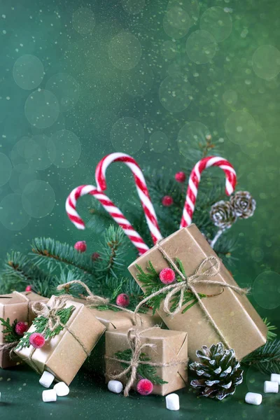 Vánoční nebo novoroční karta. Balení dárků v retro béžové kraftový papír a přírodní dekor s jedlí, cukroví hole — Stock fotografie