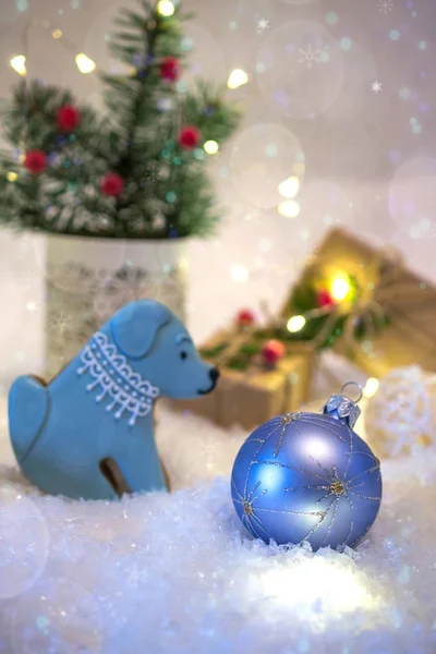 Bolachas em forma de cão. Ano Novo decoração brilhante e apresenta no fundo de luz com luzes — Fotografia de Stock