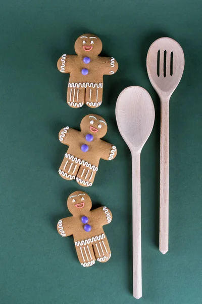 Christmas and holiday baking . Ginger men cookies with decor on  green  background.