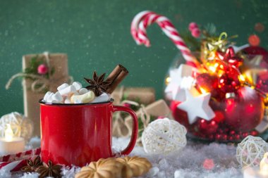 Kırmızı fincan sıcak baharatlı Noel içecek ve yeni yıl süslemeleri. Yeşil arka plan üzerinde.