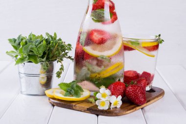 Çilek ve otlar ile soğuk taze ev yapımı limonata. Detoks maden suyu tarifi