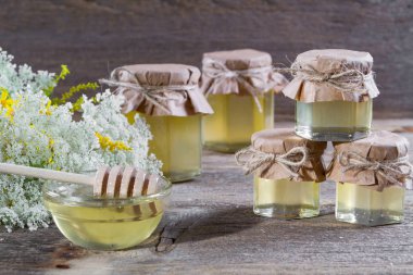 Tatlım bir cam kavanozlar, kır çiçekleri rustik ahşap arka plan üzerinde