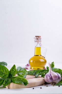 Sarımsak ve beyaz zemin üzerine zeytin yağı ile yeşil taze fesleğen