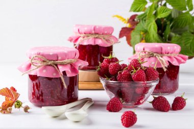 Ahududu reçeli Cam Kavanoz, taze olgun Ahududu ve yeşil beyaz tahta masada bırakır