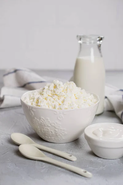 Organic farmer\'s fresh dairy products: milk, cottage cheese, sour cream. On gray concrete background.