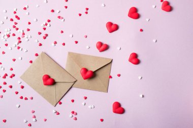 İki el sanatları çok renkli tatlı şeker şeker kalpler ile posta zarf kağıt. Aşk mesajı ya da hediye kavramı.