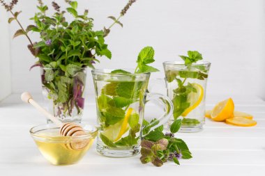 Limon ve nane cam vazo içinde sunulan bir demet taze nane çayı iki cam bardaklar