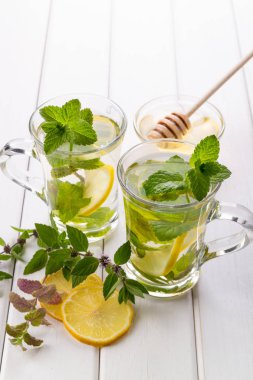 İki cam bardak taze nane çayı .limon ve ballı beyaz arka plan üzerinde.