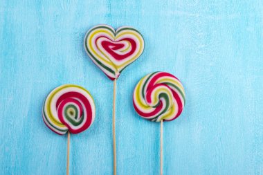 Renkli çizgili lolipop düz en az kavramı turkuaz kopya alan arka plan üzerinde yatıyordu.