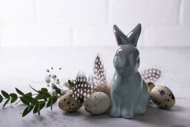 Bıldırcın yumurta ve yaprak dal okaliptüs ve seramik bunny Paskalya bahar dekoratif kompozisyon. Gri beton ile bir arka plan üzerinde metin için yer.