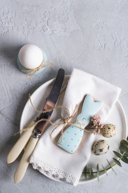 Paskalya Festival tablo Easter bunny Çerezler, ayarıyla Bıldırcın yumurta ve yumurta, yeşil yaprak dal okaliptüs, tavuk. Bir gri beton arka plan üzerinde. Tatil kutlama süslemeleri.