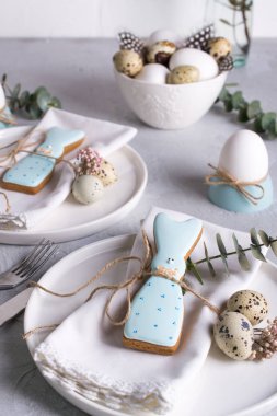 Ev yapımı Paskalya kurabiyeleri beyaz plaka üzerinde komik tavşan şeklinde. Paskalya Festival Tablo ayarı. Tatil dekorasyon.