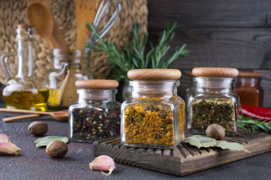 Mutfak eşyaları, otlar, Cam Kavanoz koyu arka plan üzerinde renkli kuru baharat