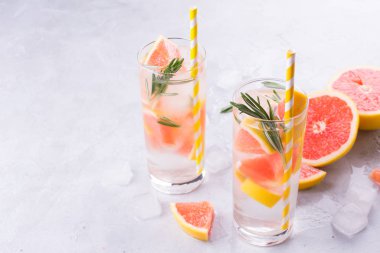 Greyfurt limonata. İki kadeh içki, serinletici su greyfurt, biberiye dalları ve buz ile. Tarifi kavramı, kokteyl