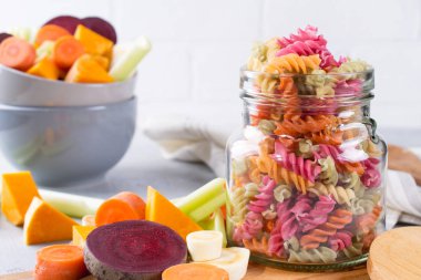 Pirinç düdük bir cam kavanoza sebze kuru makarna. Onun doğal bitkisel boya kereviz, pancar, havuç, kabak, yaban havucu. Sağlıklı gıda glutensiz kavramı