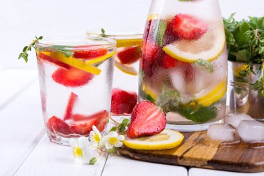 Çilek ve otlar ile soğuk taze ev yapımı limonata. Detoks maden suyu tarifi