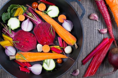 Çiğ dilimlenmiş sebze, bir fırın tepsisinde kavurma için. Sebze bahçesinden ürün yelpazesine. Sağlıklı gıda. Havuç, pancar, pazı, kabak, soğan, sarımsak, domates.