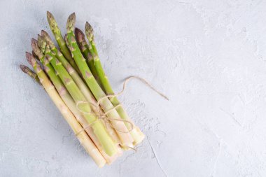 Metin arka plan için bir reçete için gri beton zemin alanı üzerine taze kuşkonmaz demet.