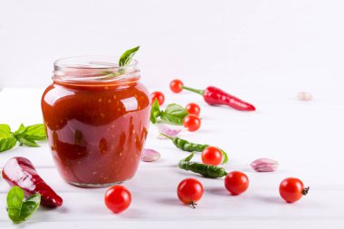 Baharatlı tatlı salça sarımsak, biber ve otlar bir cam kavanozlar.