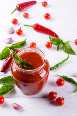 Salça, ketçap cam kavanoz ve malzemelerin üzerine beyaz bir arka plan 