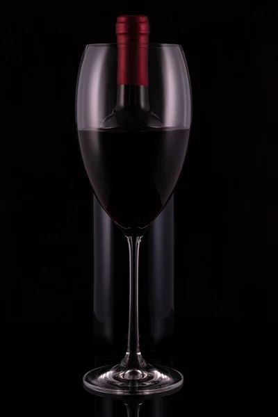 Elegantes Rotweinglas Und Schwarze Weinflasche Auf Schwarzem Hintergrund — Stockfoto