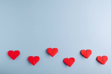 Aşk günü. Mavi arka planda el yapımı Diy kırmızı origami kalpler. Üst görünüm.