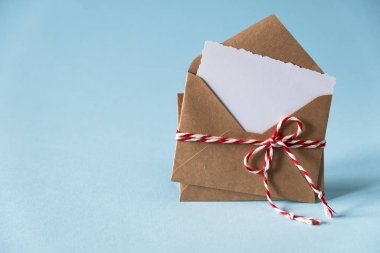 Sevgililer Günü aşk mektubu maketi. Mavi arka planda beyaz, boş bir kartın olduğu bir zarf. Sevgililer Günü, Anneler Günü, Kadınlar Günü tebrik kartı.