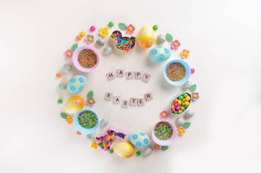 Paskalya konsepti. Düz konum, üst görünüm, kopyalama alanı. Şenlik elementlerinden yapılmış çerçeve. Kurabiye keskisi, şeker serpme, yumurta. İçinde 