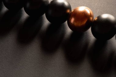 Bir altın yumurta ve siyah yumurta fotokopi alanı ile siyah arka planda yatar.