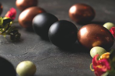 Paskalya arka planında altın ve siyah paskalya yumurtaları var. Düz konum, Üst görünüm, kopyalama alanı.