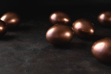 Paskalya arka planında altın Paskalya yumurtaları ve siyah arka plan. Düz konum, Üst görünüm, kopyalama alanı.