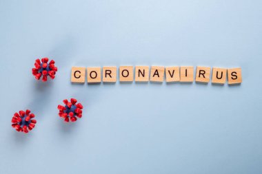 Mavi arka plan ve covid-19 virüsünün modellerinden oluşan yazıt koronavirüsü. Virüs salgını koruma konsepti.