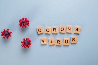 Mavi arka plan ve covid-19 virüsünün modellerinden oluşan yazıt koronavirüsü. Virüs salgını koruma konsepti.