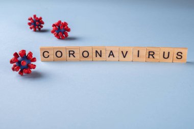 Mavi arka plan ve covid-19 virüsünün modellerinden oluşan yazıt koronavirüsü. Virüs salgını koruma konsepti.