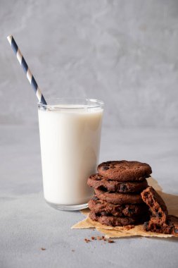 Ev yapımı çikolatalı kurabiyeler ve fotokopi alanı olan cam süt. Gri bir arkaplanda