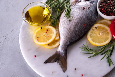 Taze çiğ Dorado kuyruğu ya da mermer tahtada baharatlar, otlar, limon ve tuzlu deniz kepeği balığı. Üst görünüm