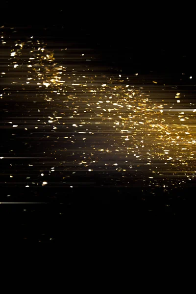 Gold sparkling star dust. Gold sparkles on a black background. shiny background. Gold glittering dust.