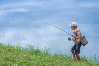 Inle Lake, Myanmar - 07 Eylül 2017 'de Inle Gölü yakınlarındaki bir köyde Birmanyalı çocuk balık tutuyor.