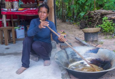 Siem Reap, Kamboçya - 15 Ekim 2017 'de Kamboçyalı kadın Siem Reap Kamboçya yakınlarında bir köy pişiriyor.. 