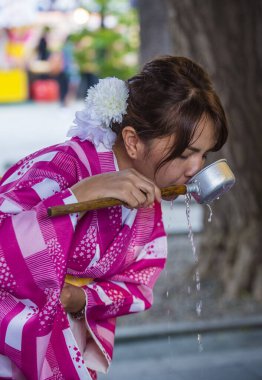 Tokyo - 17 Mayıs: Japon kadın 17 Mayıs 2018 tarihinde Tokyo 'da bir tapınakta Chozuya' da su içti. Chozuya, ayin için bir su temizleme pavyonu..