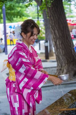 Tokyo - 17 Mayıs: Japon kadın 17 Mayıs 2018 'de Tokyo' daki bir tapınakta Chozuya 'da ellerini yıkıyor. Chozuya, ayin için bir su temizleme pavyonu..