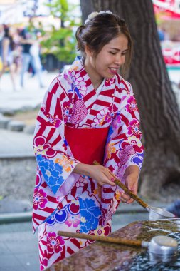 Tokyo - 17 Mayıs: Japon kadın 17 Mayıs 2018 'de Tokyo' daki bir tapınakta Chozuya 'da ellerini yıkıyor. Chozuya, ayin için bir su temizleme pavyonu..