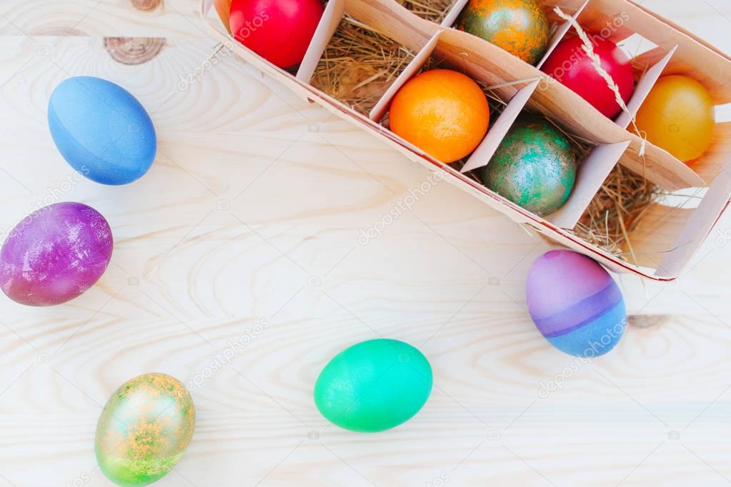 multicolored Easter eggs in wooden packing